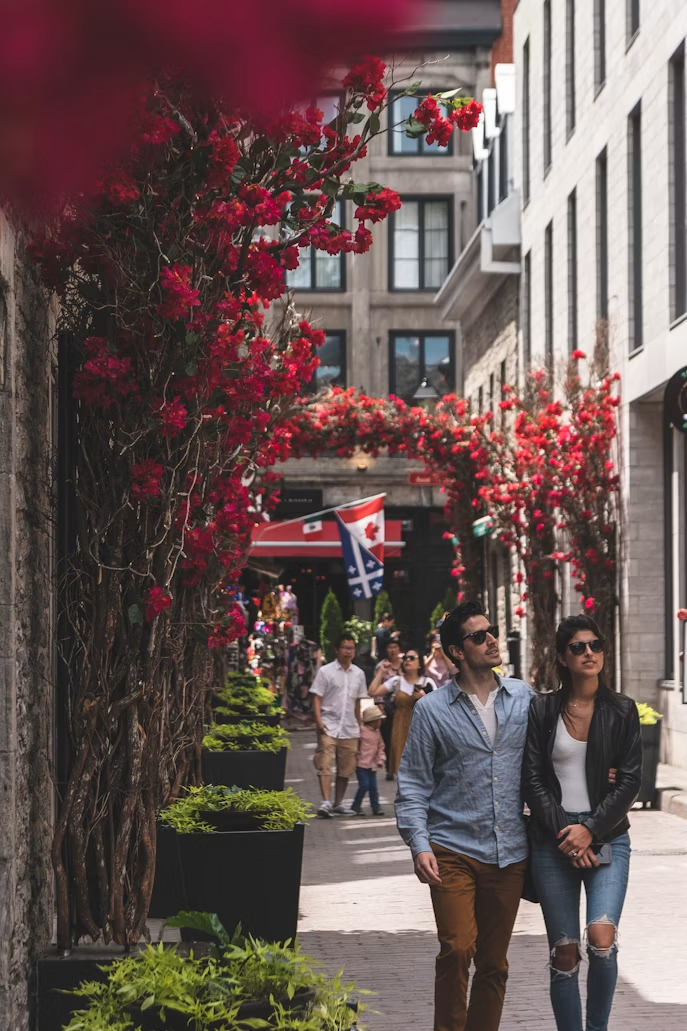 Two people walking past a flower-covered street, noticing the details around them