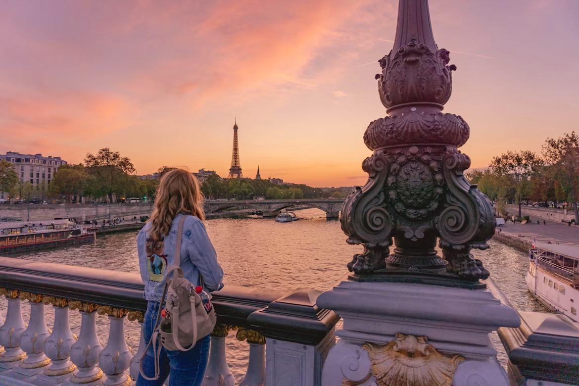 A traveler pausing on a bridge to take in the sunset